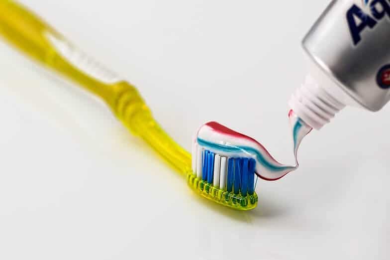 Nanošenje paste za zube na žutu četkicu za zube