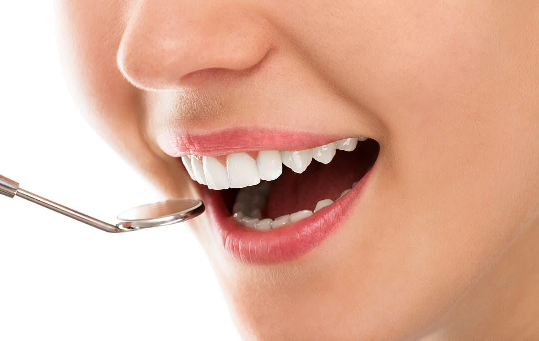 Ženska osoba se smiješi tijekom pregleda zubi